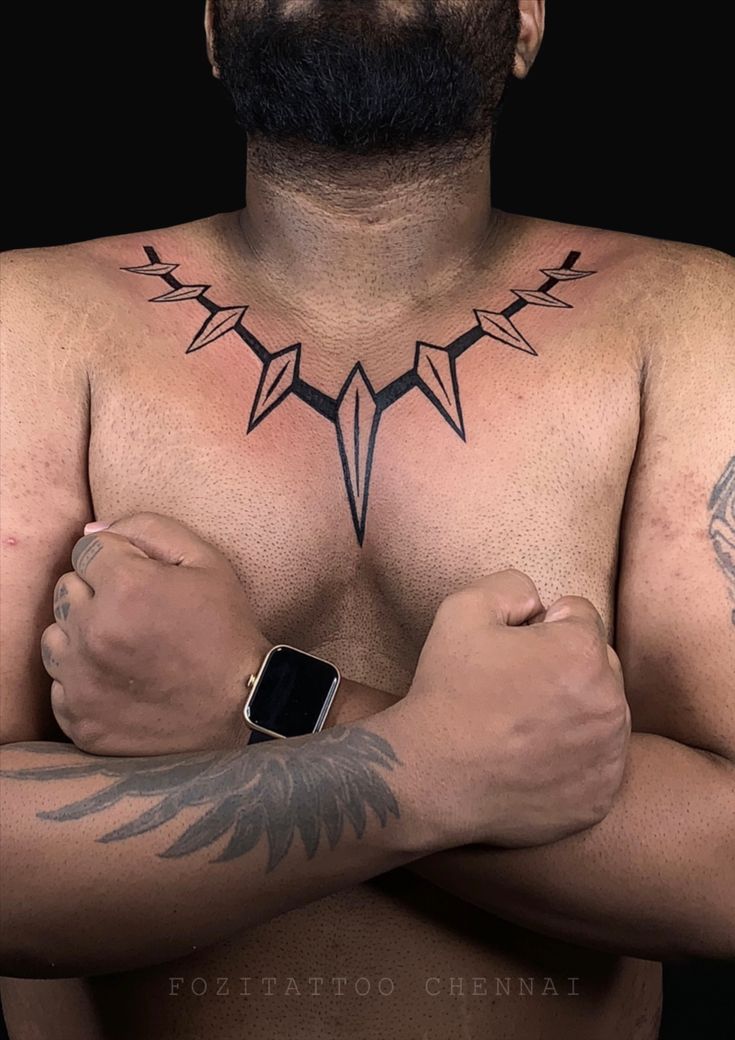 a man with tattoos on his chest and arm is looking at the camera while wearing an apple watch