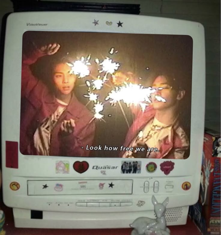 two people holding sparklers in front of a television screen with the caption look how free we are