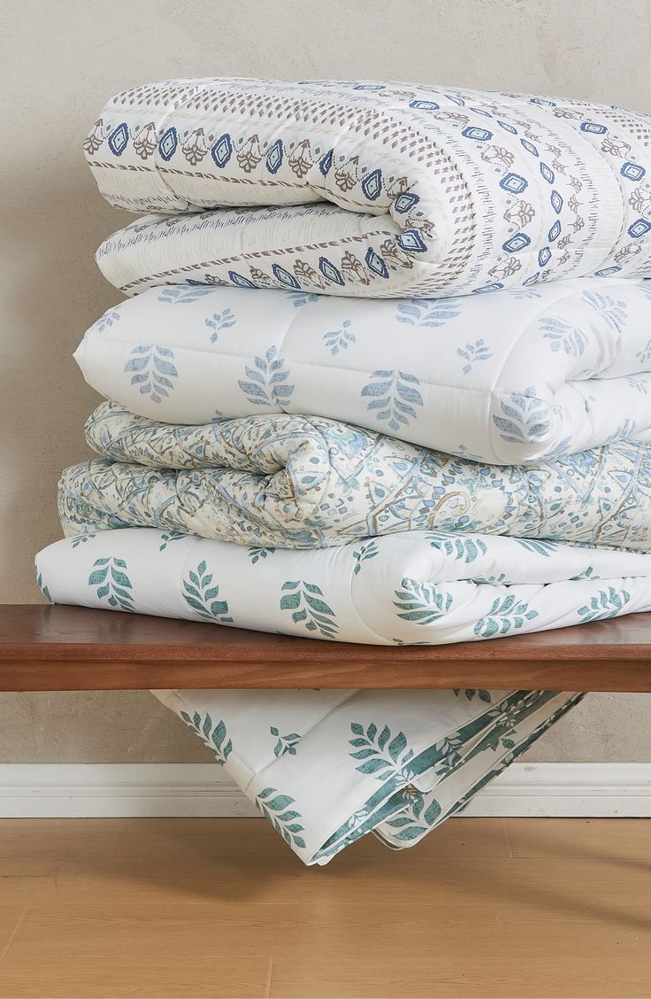 a stack of folded sheets sitting on top of a wooden table