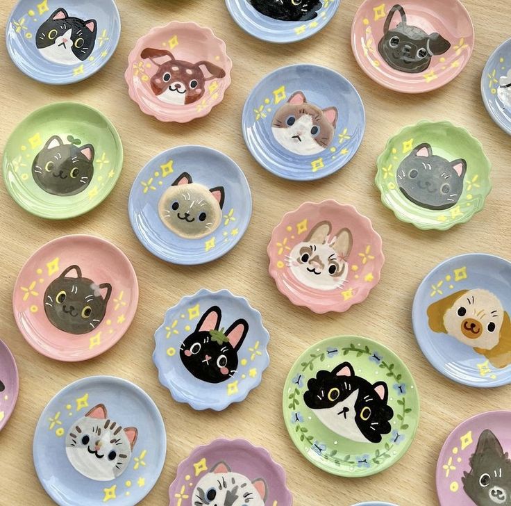 many plates with cats and dogs on them sitting on a wooden table next to each other