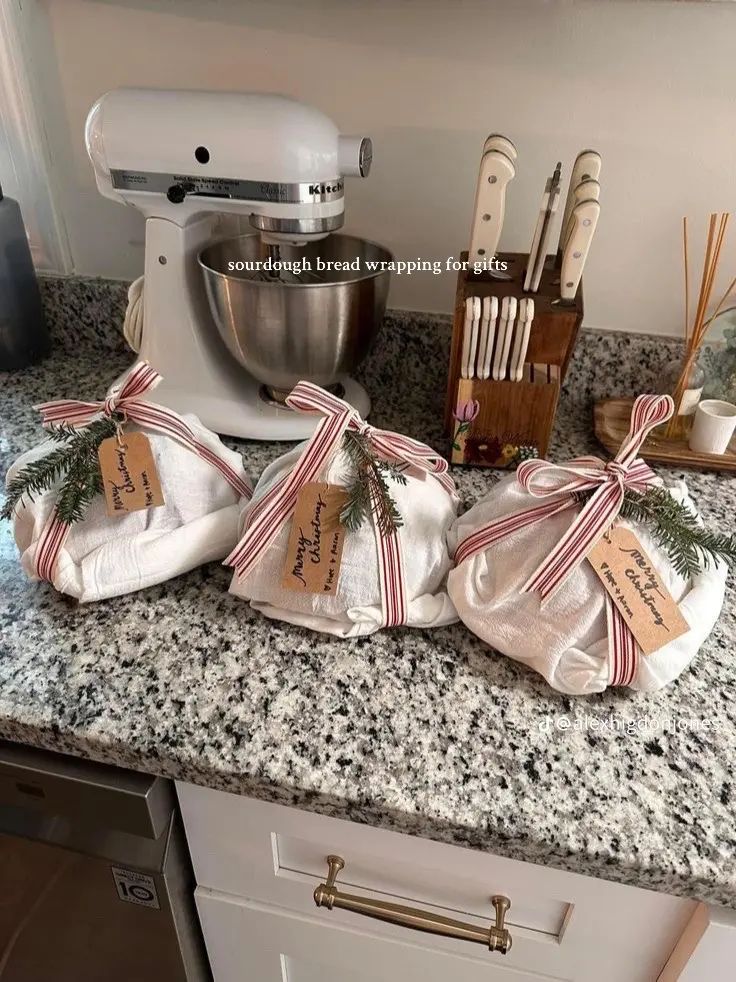 kitchen supplies wrapped in burlap and tied with red ribbon on granite counter top