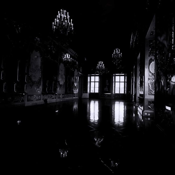 an empty room with chandeliers and windows in the dark, black and white photo