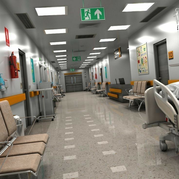 an empty hospital hallway with chairs and signs