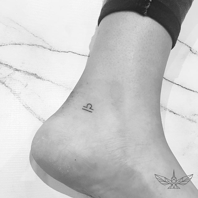 a woman's foot with a small tattoo on her left ankle and the letter q