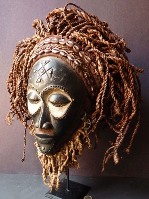 an african mask with dreadlocks on it's head