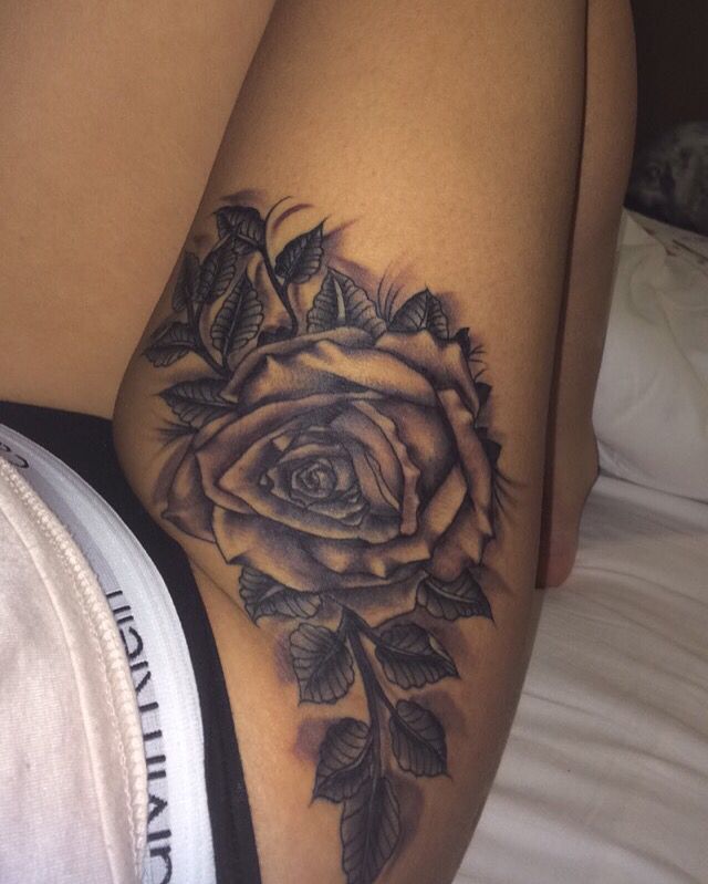 a woman's thigh with a rose tattoo on it