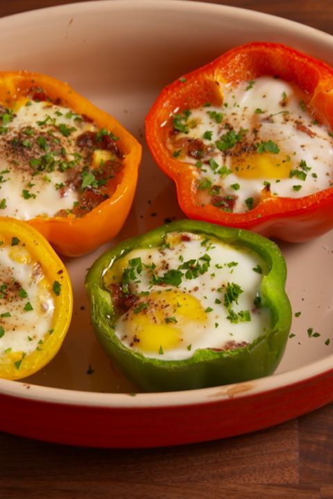 four peppers with eggs in them on a plate