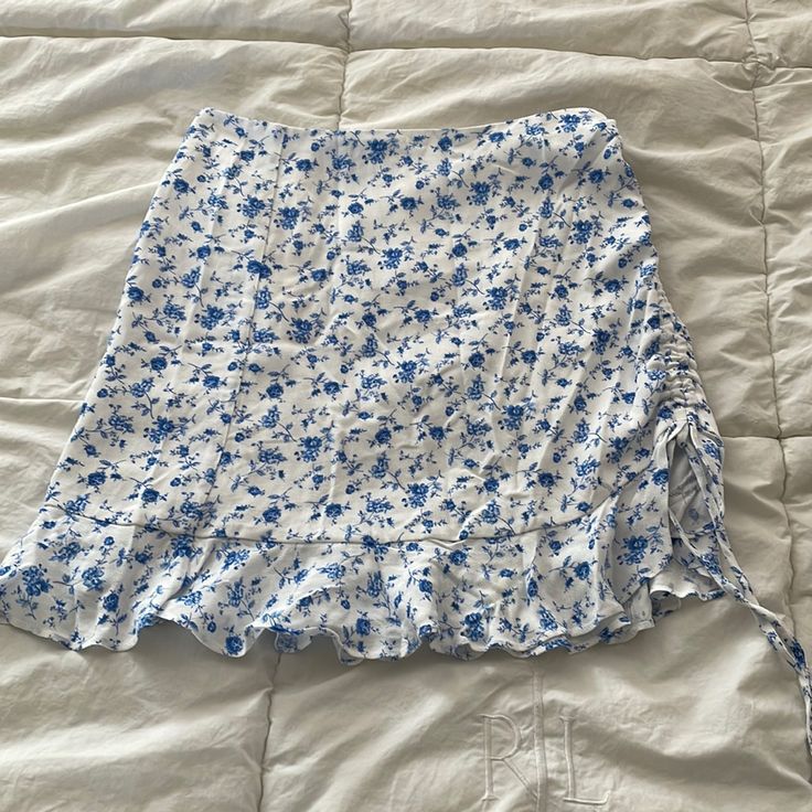 Floral Print Skirt With One Leg Ruching. Zipper In Back. Ruffle Bottom Detail. Like New, Never Worn. All Sales Final Floral Skirt Light Blue, Blue Relaxed Fit Mini Skirt With Floral Print, Flower Skirts, White Floral Print Mini Skirt, Blue Floral Print Mini Skirt, Blue Floral Print Tiered Mini Skirt, Skirts Floral, Blue Floral Skirt, Flower Print Skirt