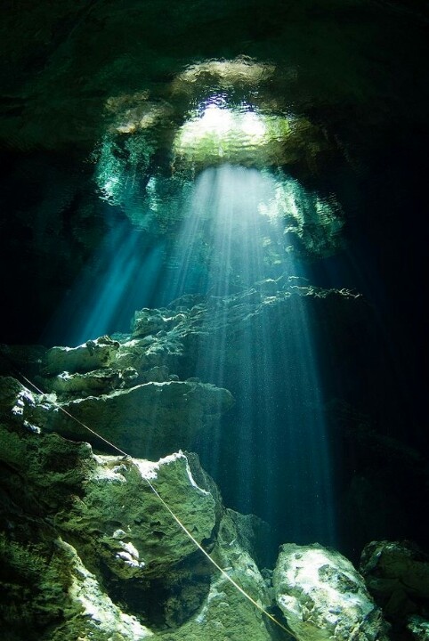 an underwater cave with sunlight shining through the water