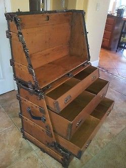 an old wooden chest with four drawers on the bottom and one drawer open to show it's contents