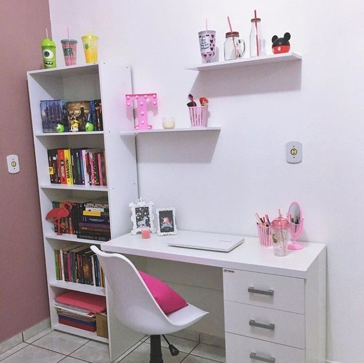 a white desk topped with a laptop computer next to a book shelf