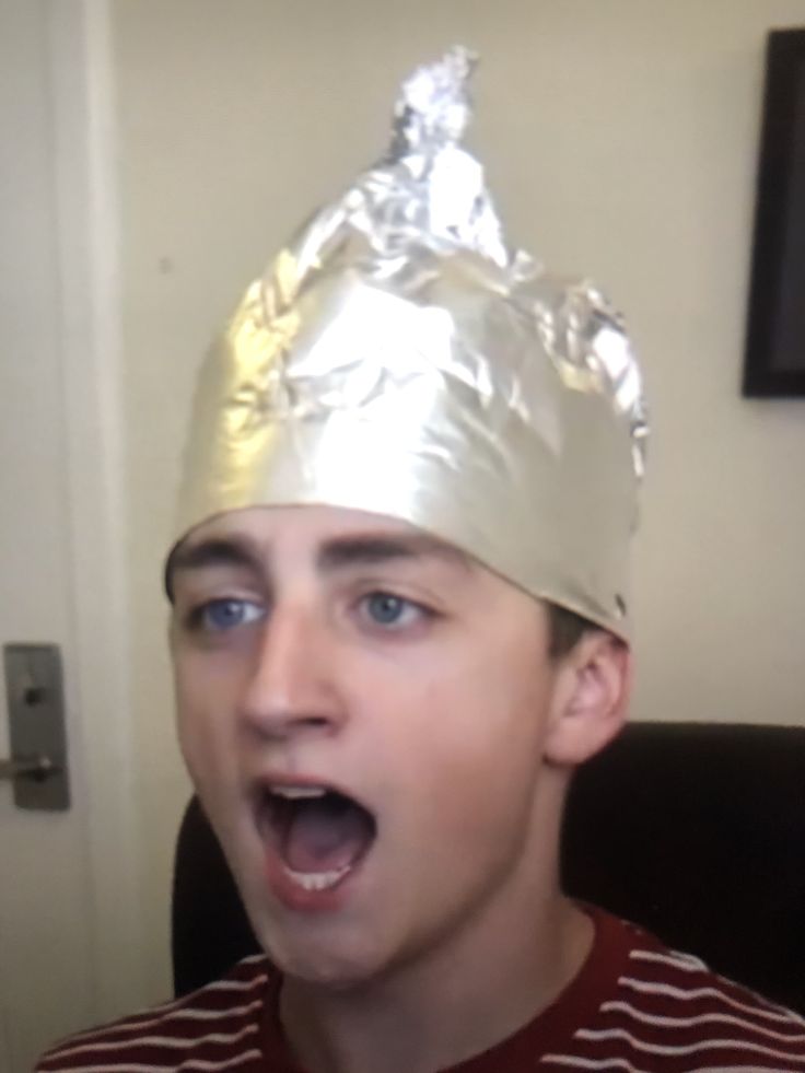 a young man wearing a tinfoil hat with his mouth open