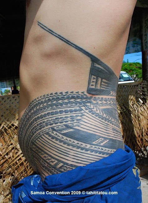 a man with a tattoo on his stomach is standing in front of straw bales