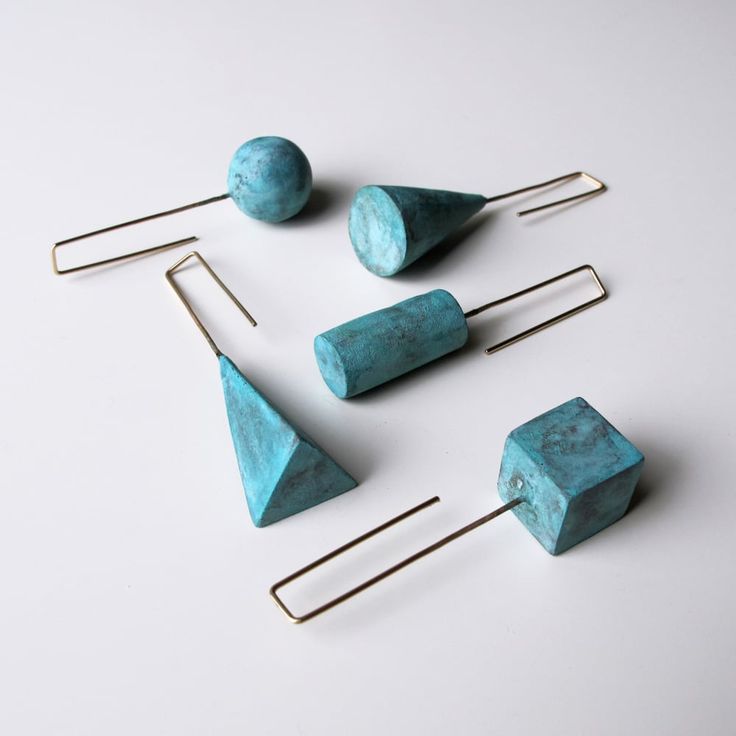 five pieces of turquoise colored stone with metal pins and hooks on white surface, including one piece of wire