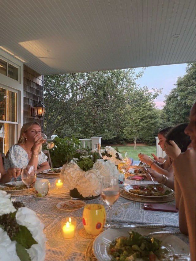 a group of people sitting around a table with food and drinks on top of it