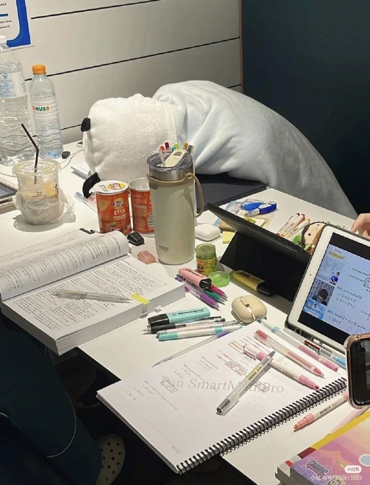 a person sitting at a desk with an open laptop and various office supplies on it