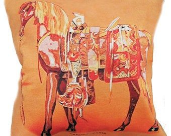 an orange pillow with a horse painted on it