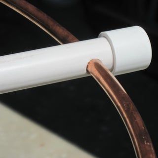 a close up of a white and brown bicycle handlebars with copper bars on it