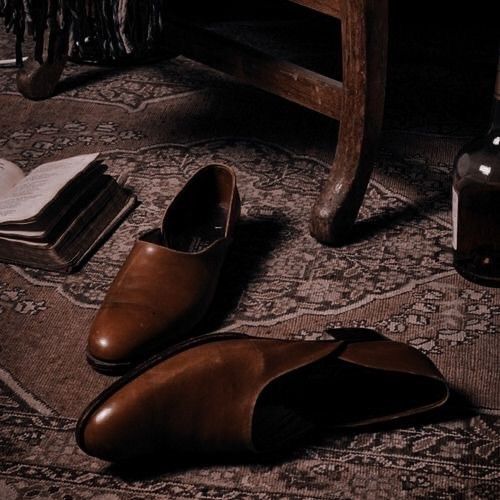 a pair of brown shoes sitting on top of a rug