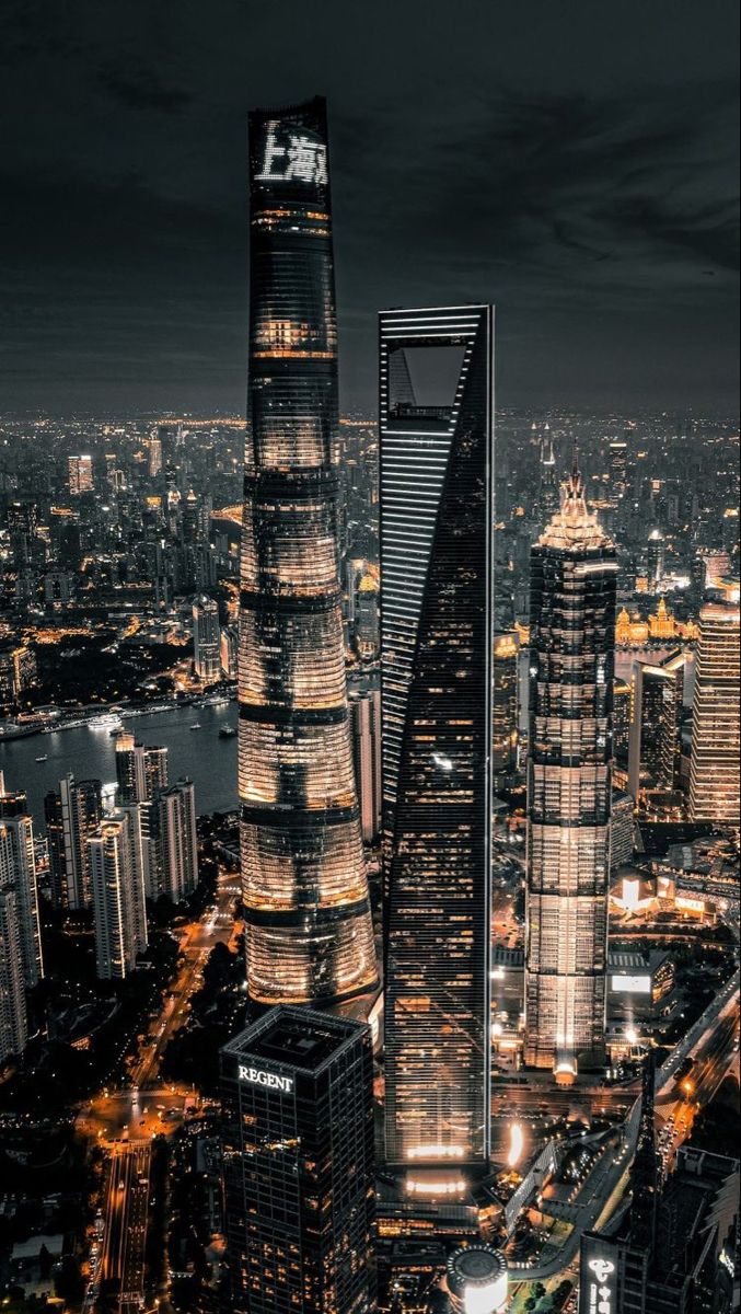 an aerial view of a city at night with skyscrapers lit up in the background