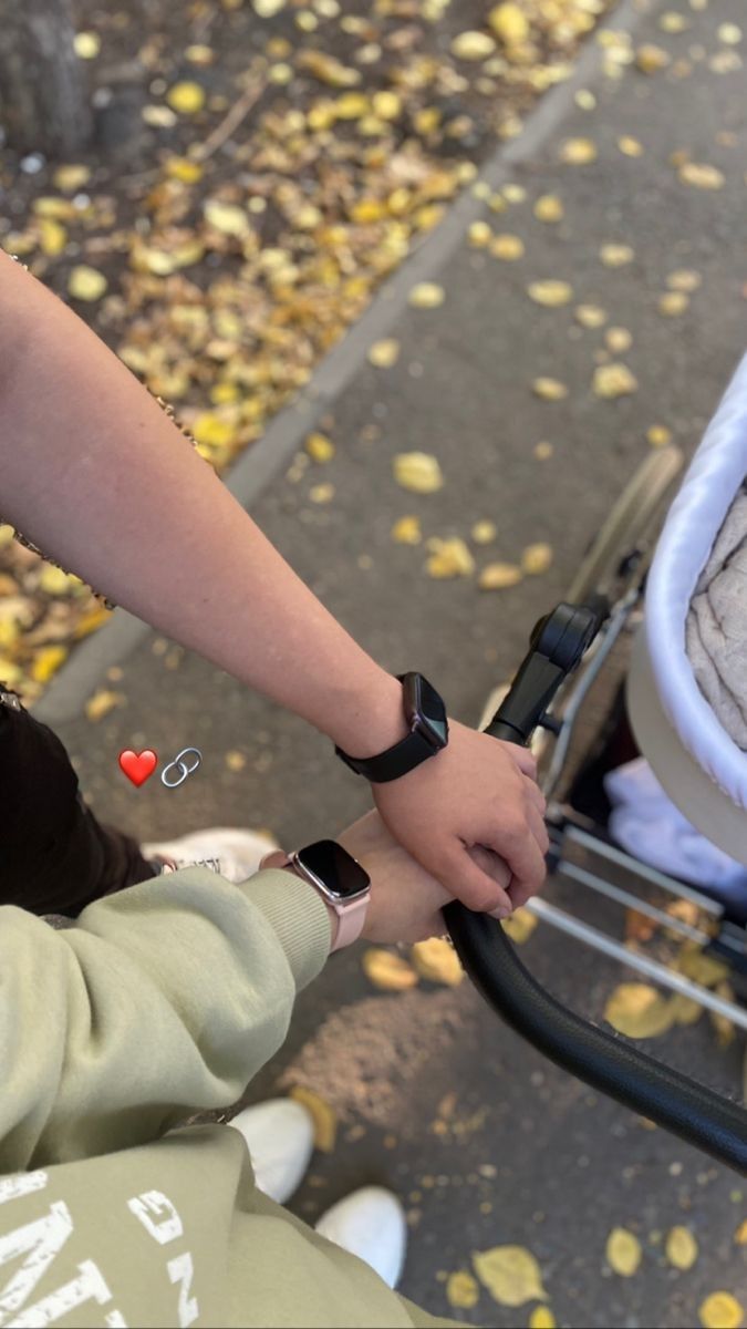 a woman holding the hand of a child in a stroller