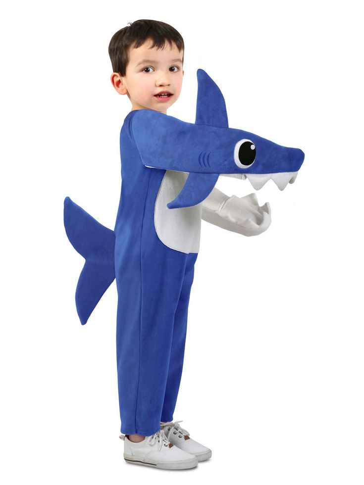 a young boy in a blue shark costume standing up with his hands on his hips