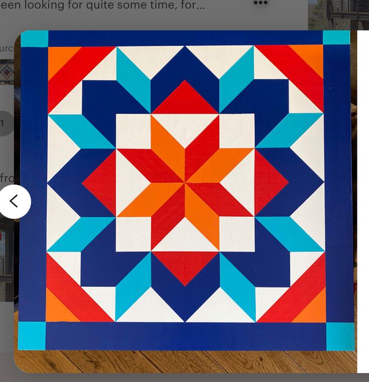 a blue and orange quilt on a wooden floor