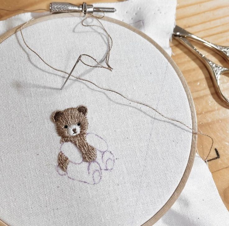 a teddy bear is stitched onto a piece of fabric