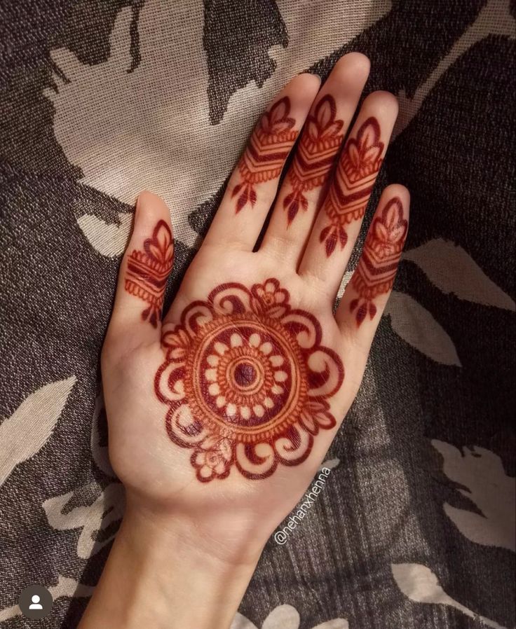 a woman's hand with henna tattoos on it