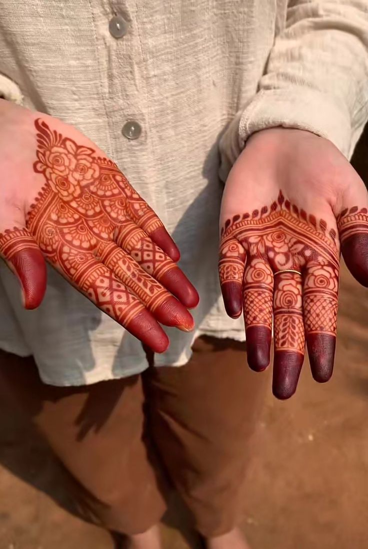 two hands with henna designs on them