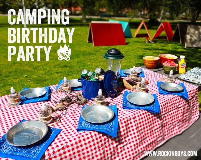 a picnic table set up with plates and bowls for camping birthday party in the park