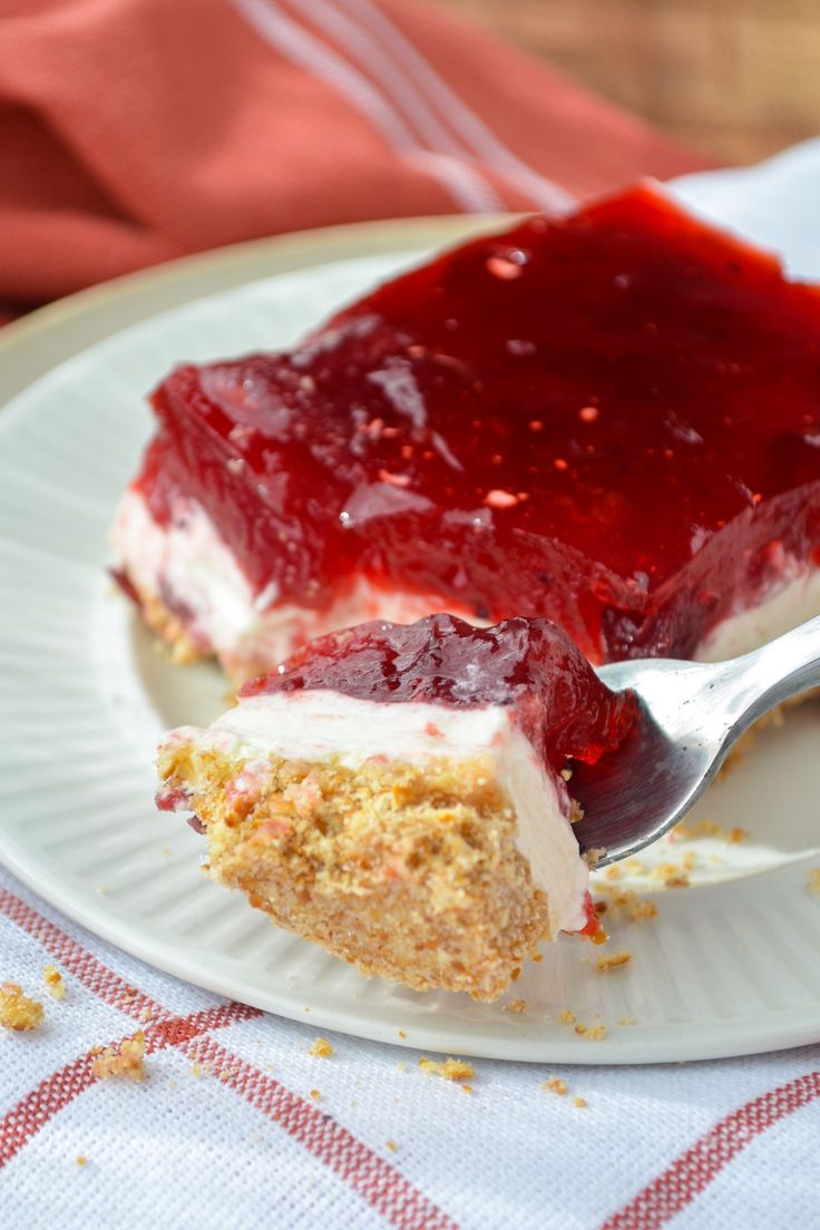 a piece of strawberry cheesecake on a plate with a fork