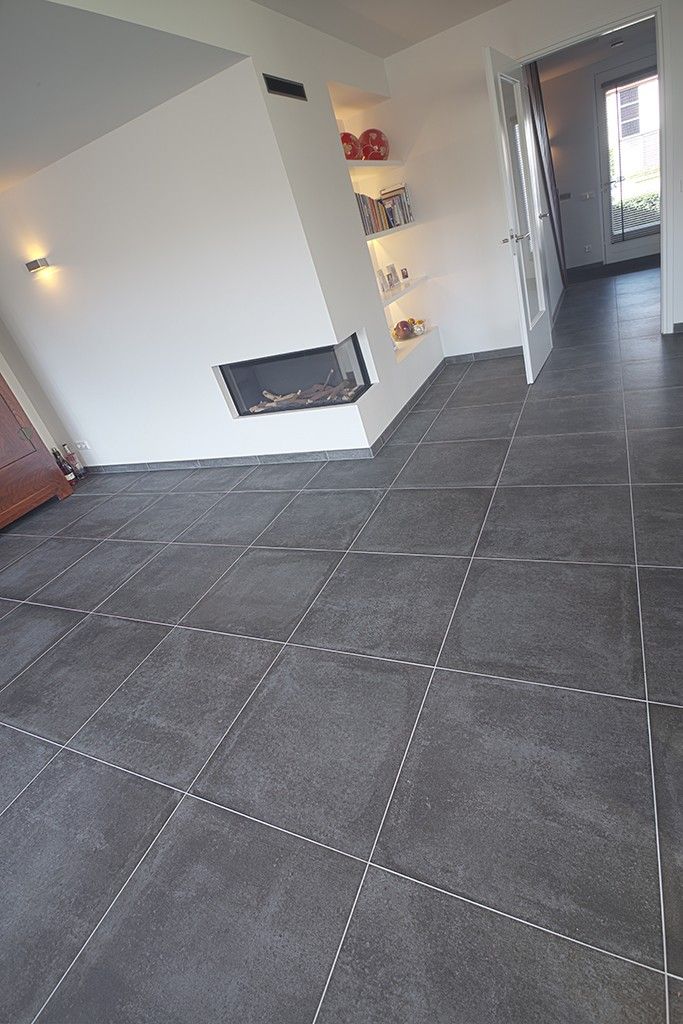 an empty living room with tile flooring and white walls