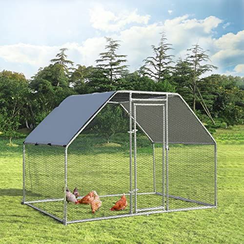 a chicken coop in the middle of a grassy field