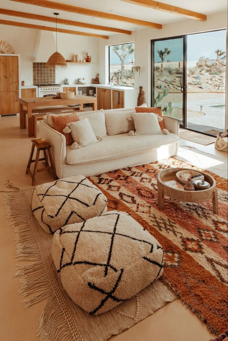 a living room filled with furniture and a large window overlooking the ocean in front of it