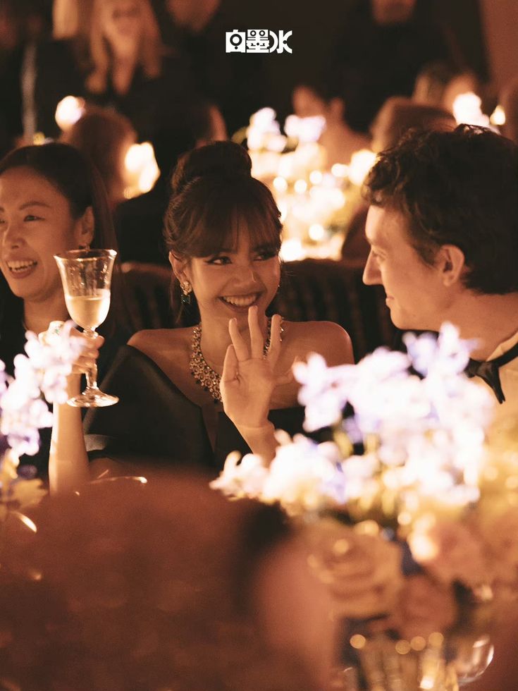 a man and woman sitting at a table with wine glasses in front of their faces