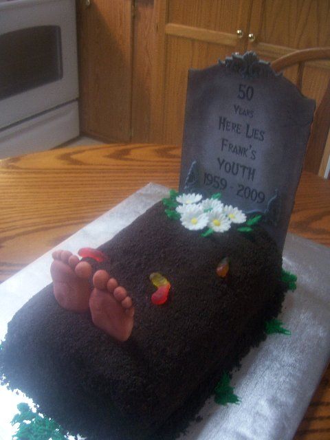 a cake shaped to look like someone's feet on top of a grave stone