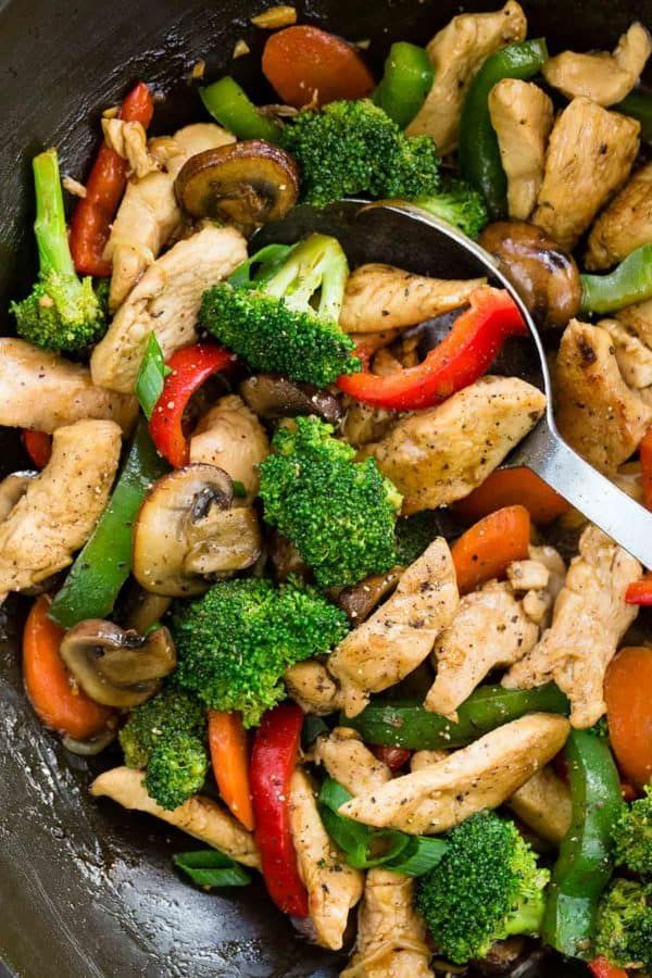 a skillet filled with chicken, broccoli, peppers and bell pepper stir fry