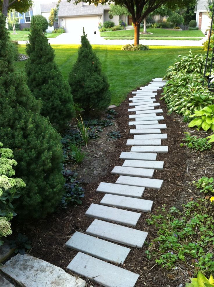 a stone path in the middle of a garden