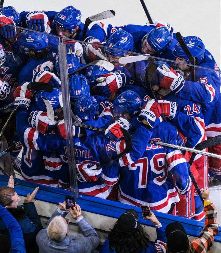 a group of hockey players huddled together in the back of a truck with their arms around each other