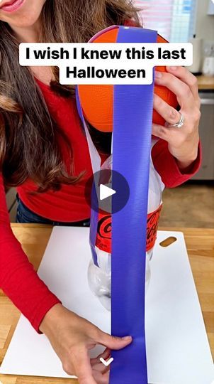 a woman is holding an orange and purple object in her hands while she looks at it