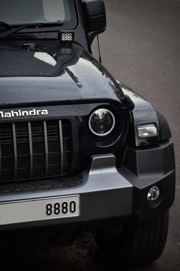 the front end of a black jeep parked in a parking lot