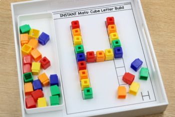 a white tray with legos on it and a letter h in the middle that says instant match cube letter build