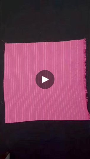 a pink piece of cloth with a white button on the center and black border around it