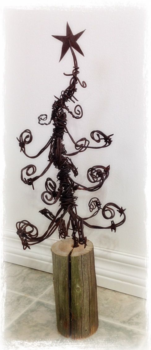 a wire christmas tree on top of a wooden stump