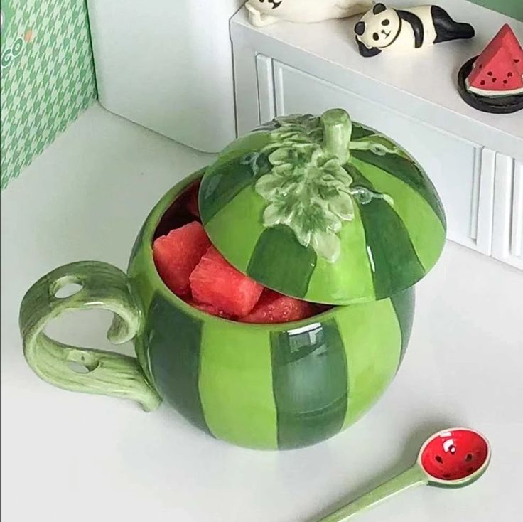 there is a green bowl with watermelon slices in it