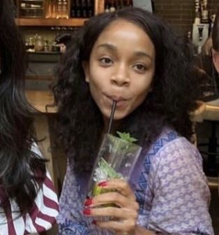 three women are drinking drinks in a bar and one is sticking her tongue out to the side