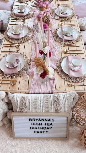 a table set for a high tea birthday party with pink and white decorations on it