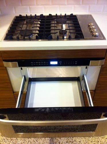 an oven with two burners and one door open on a counter top in a kitchen