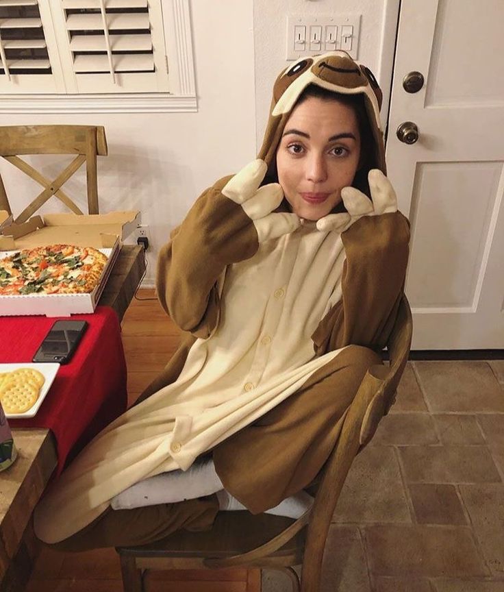 a woman sitting in a chair with her hands on her head and wearing a costume